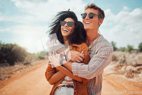 Image of Happy couple, hug and love, smile and travel on roadtrip to the outback of Australia. Adventure, fun and happiness for quality summer vacation time, boyfriend and girlfriend on a desert road.