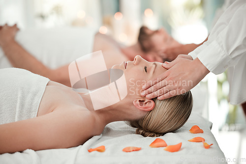 Image of Woman, spa and massage on head while on bed with flowers for relax, wellness and calm on vacation. Luxury, health and physical therapy for couple at hotel, salon and hands on scalp for natural care