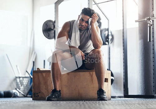 Image of Fitness, gym and man sitting on box with smile, rest and motivation during sports workout. Health, exercise and weightlifting, time to relax, bodybuilder from Brazil with towel on break from training