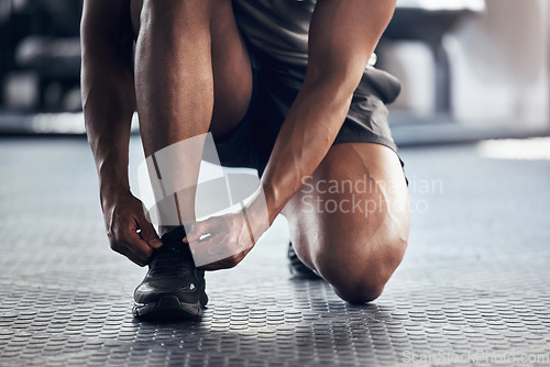 Image of Gym, shoes and hands with shoelace ready with man floor to workout, exercise or fitness. Sport, health and wellness at training facility for cardio, mma or crossfit class for athlete body development
