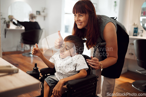 Image of Hair salon, hairdresser and child in wheelchair with thumbs up after haircut. Hairdressing, barber and haircare for kid with disability. Support of accessibility, smile and thank you from happy boy