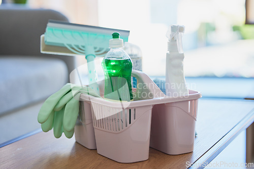 Image of Basket, cleaning and product on table in home, office or room. Chemical, liquid and bleach in bottle to spray, brush and hygiene against virus, bacteria and germs on desk at workplace in Cape Town