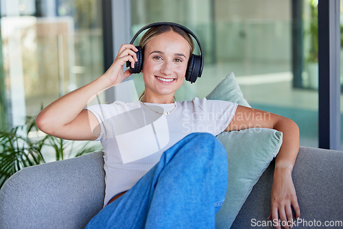 Image of Relax, music and woman listening to radio or podcast on a sofa, cheerful and smile in a living room. Freedom, portrait and streaming by happy, content female enjoying peace and online media audio