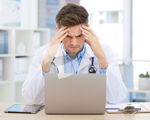 Image of Stress, anxiety or burnout for doctor with laptop working on medicine, medical or healthcare research. Headache, head pain or migraine for hospital employee, worker or career man with digital tech