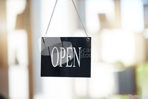 Image of Small business, cafe and advertising with open sign for marketing, board or start of opening hours. Welcome, entrance and door of startup shop, restaurant or store in window of retail coffee shop