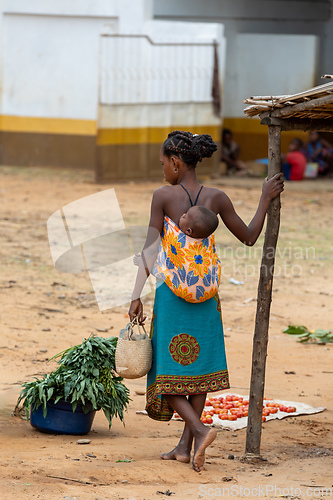 Image of Woman carrying child on her back in Bekopaka, Madagascar