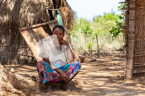 Image of Malagasy woman in front of her hut resting in shaddow. Belo Sur Tsiribihina, Madagascar