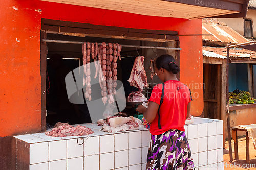 Image of Woman buys meat from a street butchery in Mandoto, Madagascar.