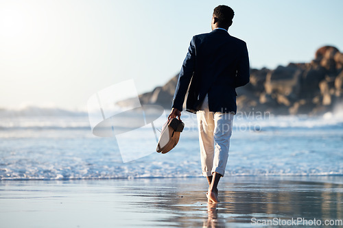 Image of Business man relax at beach, walking on sand with shoes in hand and calm holiday at California sea. Sunset waves break on weekend, summer travel freedom with zen blue sky and ocean vacation travel
