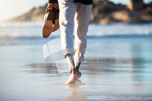 Image of Man, beach and walking feet in water in summer with shoes in hand to relax, breathe and thinking. Ocean, walk and sunshine for mindfulness, calm and peace at sea, nature and outdoor in Cape Town