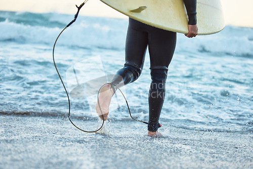 Image of Legs, surfboard man at beach and ocean waves for fitness, adventure and healthy lifestyle on Bali summer tropical vacation. Surfer running in sea water, relief of stress and surfing in wet suit.