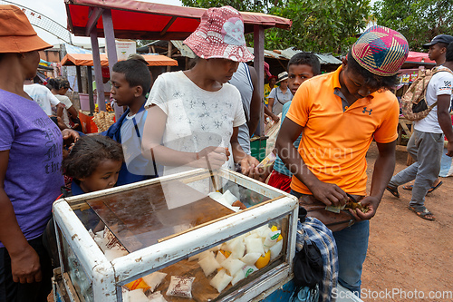 Image of Malagasy man sell milk product from simple cooling case on the street of Mandoto.