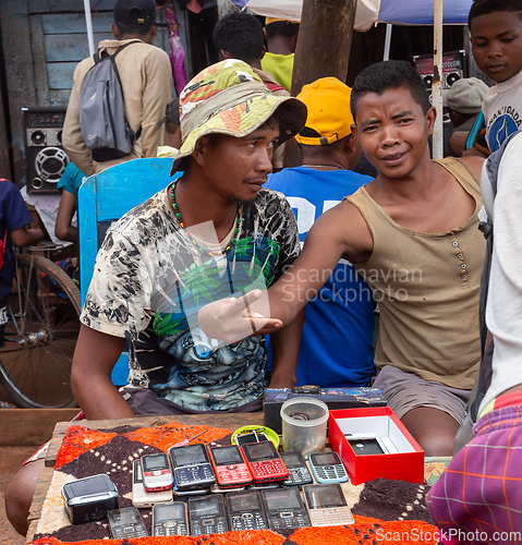 Image of Malagasy man sell old fashioned cellular mobile phones on the street. Mandoto, Madagascar