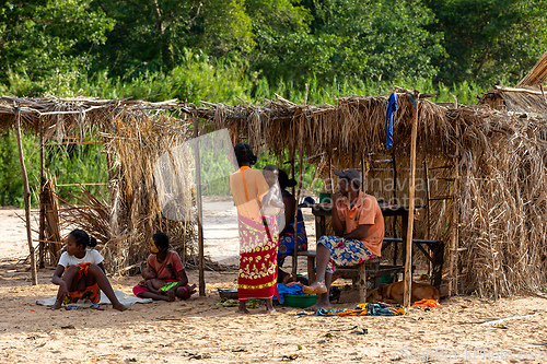 Image of Malagasy woman in front of her hut resting in shaddow. Bekopaka, Madagascar