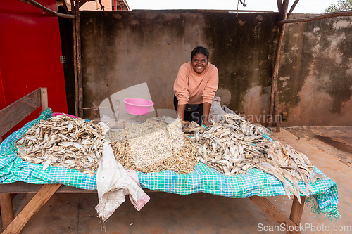 Image of Malagasy woman buys dried fish at a street market. Fishing is one of the livelihoods in Madagascar.