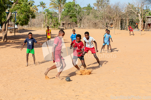 Image of Children from Kivalo village playing soccer with a handmade textile ball behind their school.