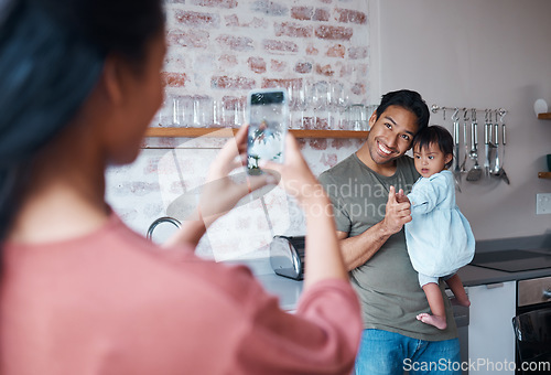 Image of Family, care and mother with phone for photo of father and baby with down syndrome in the living room of their house. Mom taking a picture of a happy dad and child with special needs on a smartphone