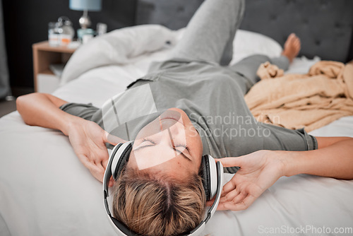 Image of Relax on bed, woman with headphones and streaming music online. Radio, podcast and content for entertainment on the internet. Girl with free time listening on earphones in bedroom at home in peace.