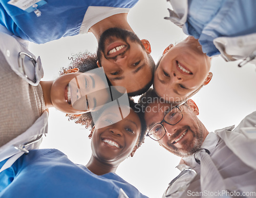 Image of Team, diversity and doctors in circle from below, teamwork, support and help from hospital staff. Group of medical workers in huddle looking down head together. Teammates, men and women in healthcare