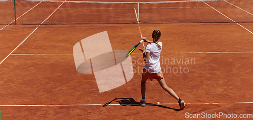 Image of A young girl showing professional tennis skills in a competitive match on a sunny day, surrounded by the modern aesthetics of a tennis court.