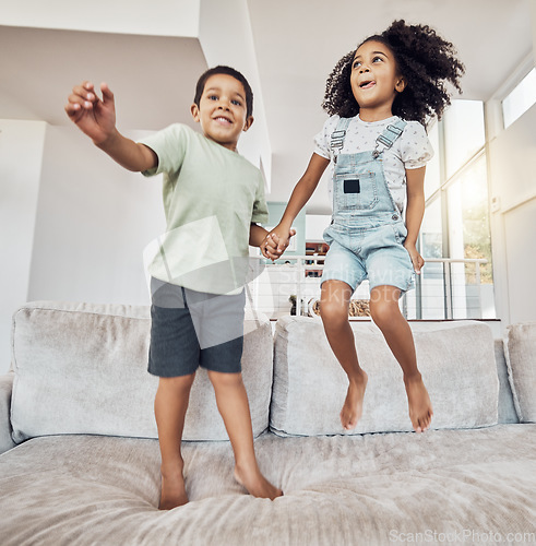Image of Children, brother and sister bonding and jumping on sofa in house, home or hotel living room in fun, play and energy game. Smile, happy or adhd kids or hyperactive Mexico boy and girl with sugar rush