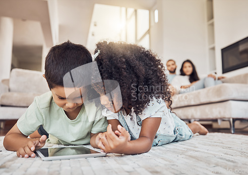 Image of Children, brother and sister on tablet watching, learning or streaming educational videos, games or cartoon on lounge carpet at home. Kids playing on internet for fun and entertainment in brazil