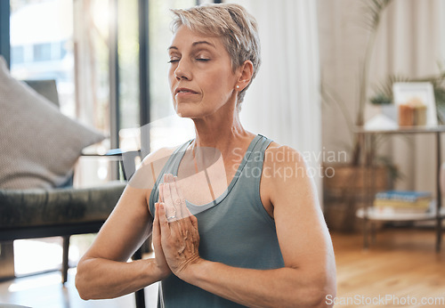 Image of Senior woman, yoga and meditation at home for exercise, wellness and health during zen practice for peace, balance and mindfulness. Fitness, retirement and fit old lady in prayer position to meditate