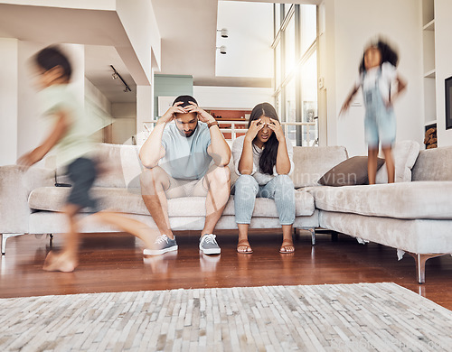 Image of Stress, headache and family with children running in living room with parents on sofa with fatigue, mental health or tired. Crazy, noise and youth with kids playing with frustrated mother and father