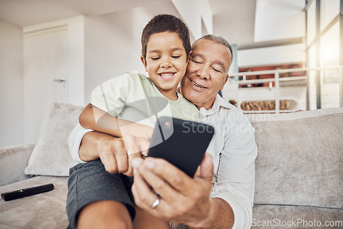 Image of Grandfather, kid and phone on sofa in home playing games or old man learning social media from boy. Love, relax and grandpa with child on 5g mobile, app or smartphone web surfing and bonding together