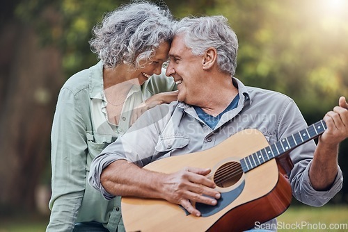Image of Senior couple, guitar and love in a park together playing a romantic, love or affection music song for wife. Romance, retired senior man and woman play string instrument and laugh outdoor in forest