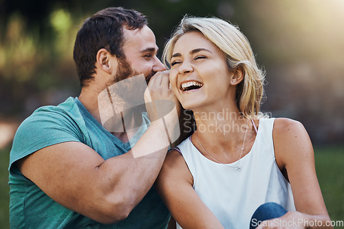 Image of Gossip, secret and funny story with couple on a romantic date in nature in Australia in summer. Man talking in a whisper into the ear of a young laughing woman while happy in a garden together