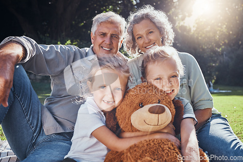 Image of Family, children and teddy bear with a girl, grandparents and sister on the grass in a nature park during summer. Kids, haooy and love with senior man, woman and grandchildren outdoor in the day