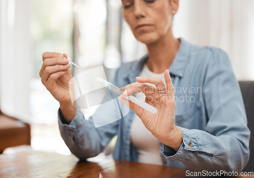 Image of Woman, hands and covid for PCR, test or results on table for healthcare diagnosis at home by desk. Sick female testing for corona virus, disease or illness holding kit for self screening in pandemic