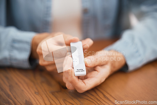 Image of Covid, healthcare and rapid antigen test in the hands of a man at home testing for infection and waiting for results. Health, medical and insurance with a testing kit for corona and examination