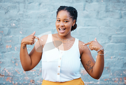 Image of Black woman, pointing and happy feeling proud and self assured choosing herself against city building wall, mockup space or outside in Nigeria. Portrait of African model with a fun or playful gesture