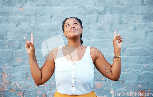 Image of Smile, happy or comic black woman pointing up by building city wall background mockup design for marketing. Fashion, trend or style model or fun and cool Nigerian student by advertising mock up space