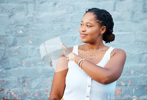 Image of Black woman pointing finger to show advertising, promo or commercial mockup, marketing space on blue wall outdoor gen z, youth lifestyle. African girl or student with hand sign to information mock up