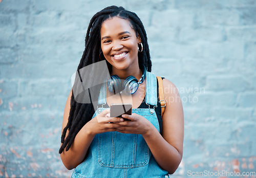 Image of Black woman, happy and phone in city on travel, walk or adventure in urban street. Girl, smartphone and smile against wall in Atlanta on vacation, holiday or break while in communication online