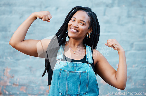 Image of Happy black woman, portrait smile and muscle power, strength and confident pose on wall background. Proud African female flexing biceps, muscles and smiling for women empowerment in South Africa