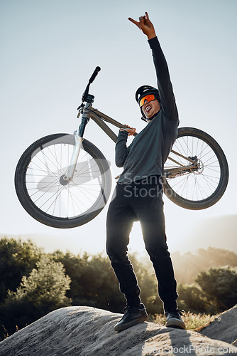 Image of Man, mountain and bike celebrate, happy and excited after reaching summit in training. Cyclist, bicycle and rock in nature, lift hand and success in sport adventure for fitness on hill in Argentina