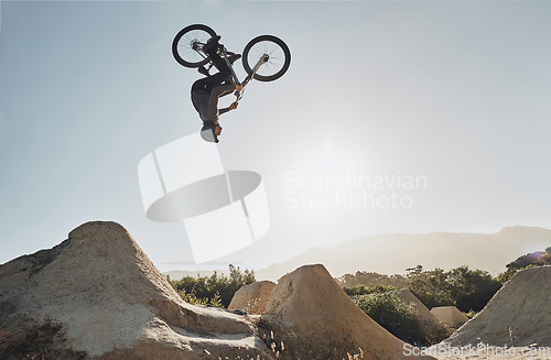 Image of Mountain bike jump training man on rocks hill cycling in air, blue sky mockup for professional performance, training or outdoor bike exercise. Sports person on outdoor motorcycle or bicycle adventure
