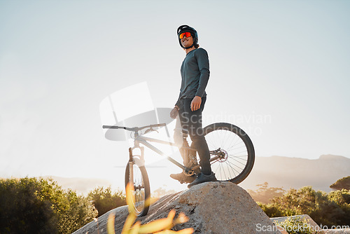 Image of Mountain bike or motorcycle cyclist on rock for marathon goal, sports adventure or outdoor travel with sunglasses and helmet. Fitness training man with bicycle on a hill blue sky mockup in Australia
