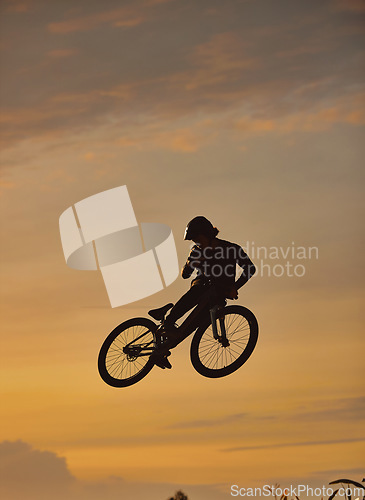 Image of Mountain bike, cyclist and fitness jump at sunset in Colorado countryside nature in workout, exercise or training. Danger risk, extreme bmx sports or freedom cycling man in sunrise with stunt energy