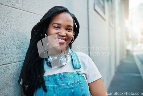 Image of Black woman, smile and happy urban student girl on city street smiling and leaning against a wall outside on commute to college. Portrait of an African gen z female outdoors traveling in South Africa