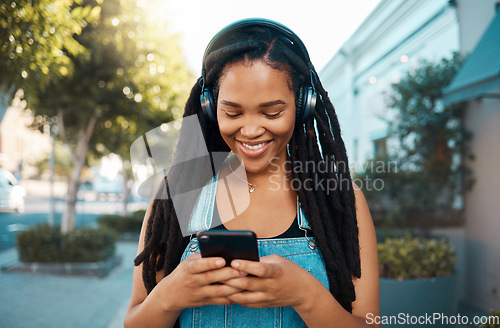 Image of Black woman, music headphones and phone with smile for 5g communication and audio streaming outdoors. Happy African female smiling, listening to playlist, texting and social media in South Africa