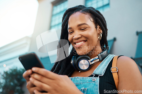 Image of Black woman with a phone in the city, search for online podcast or radio, happy looking for music to listen to. Freedom, relax and smile by African American female enjoying free time and streaming