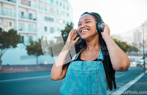 Image of Music headphone city streaming, happy and black woman smile outdoor from Atlanta. Happiness of a person feeling relax freedom and cheerful mindset listening to audio and song track near the street