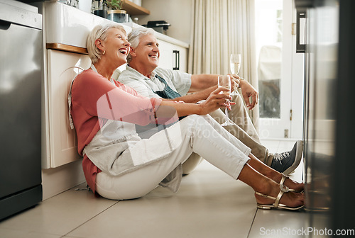 Image of Senior couple, wine and laughing on kitchen floor thinking happy memories and talking about love during a celebration of anniversary, new home or retirement. Old man and woman telling a funny joke