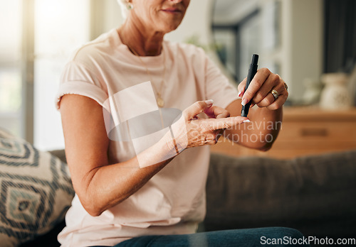 Image of Diabetes, health and elderly woman doing a blood sugar test on her finger with a glucometer. Sickness, healthcare and diabetic senior lady checking her glucose level sitting on a sofa at home.