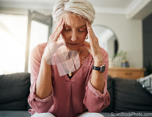 Image of Senior woman with headache pain, stress and depression while feeling tired, burnout and anxious on sofa in home. Anxiety and sad female with mental health or frustrated while thinking of life problem